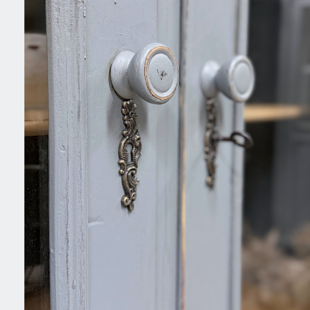 Period-style escutcheons and round wooden knobs on hand-finished reclaimed pine glazed cupboard doors, authentic vintage hardware