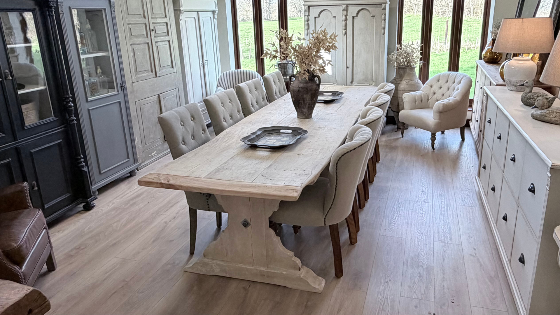 Dining room with a long wooden table and chairs in a well-lit room.
