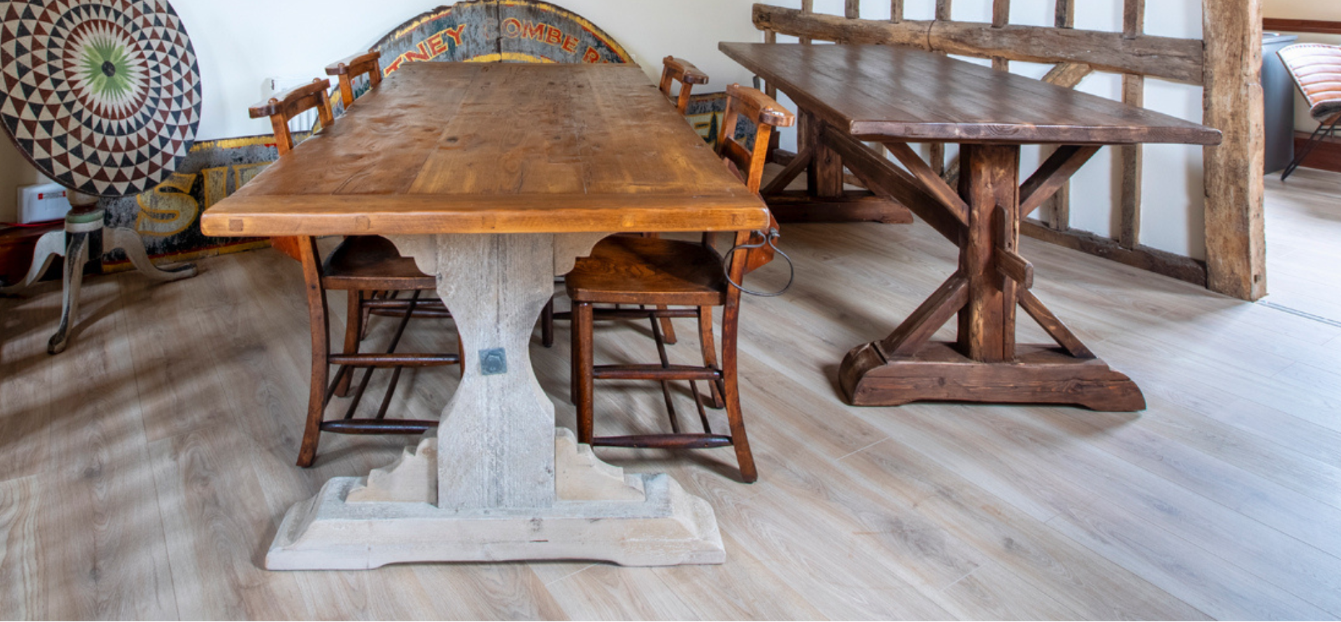 Wooden dining table with chairs in a room with wooden beams and a rug.