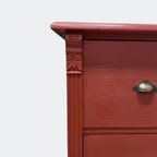 Close-up of vintage-style metal cup pulls on a handcrafted "Rusty Nail" red solid-wood drawer unit.