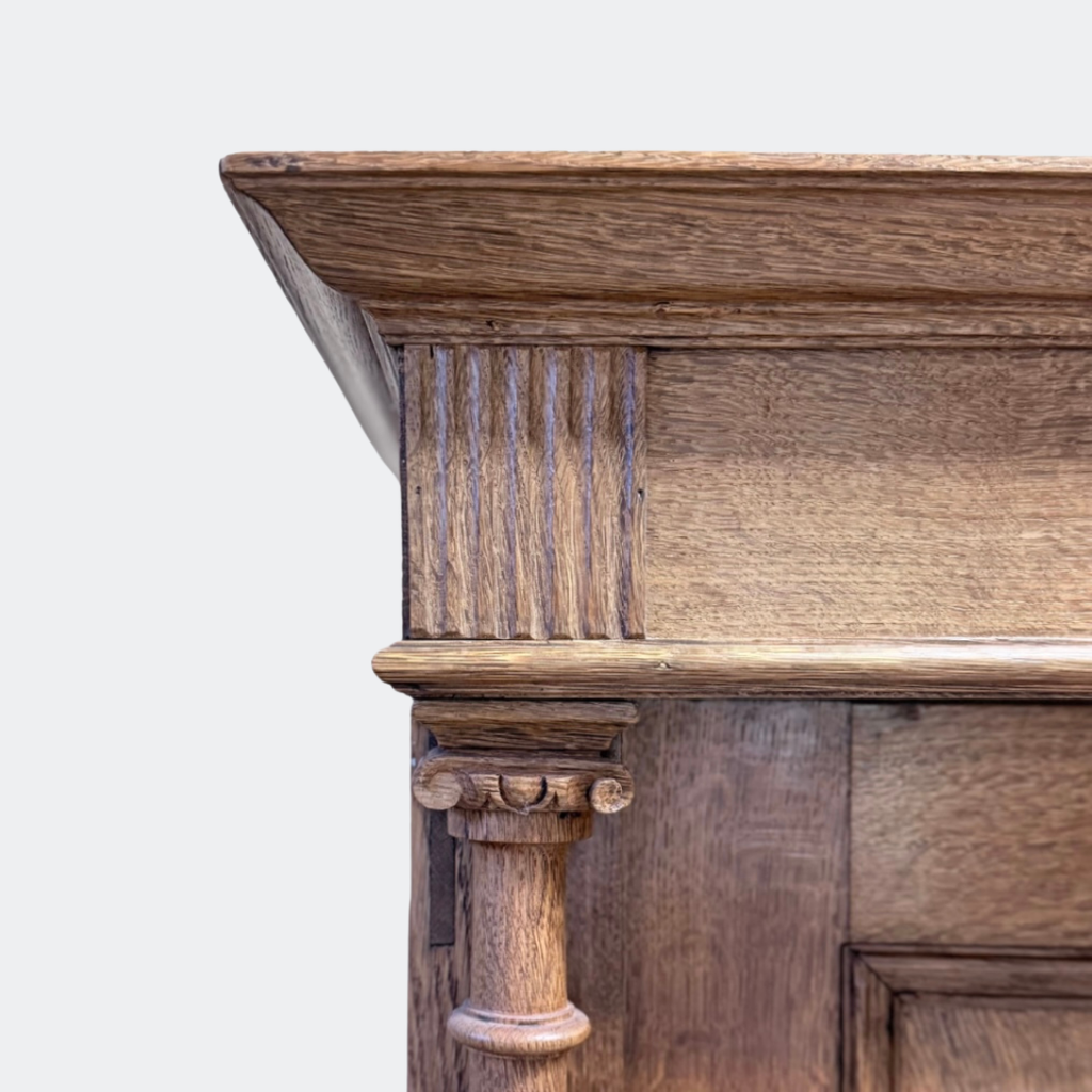 Hand-turned oak column framing and panelled door detail on vintage solid oak wardrobe, traditional European craftsmanship, authentic historic patina